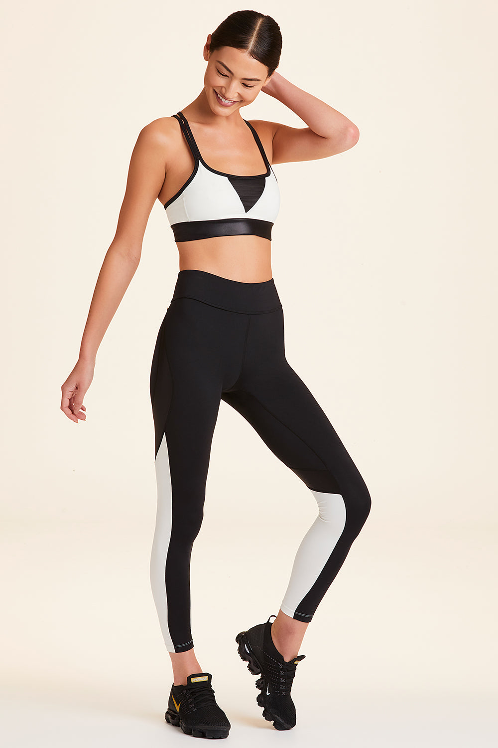 3/4 view of Alala Women's Luxury Athleisure black and cream color-blocked tight