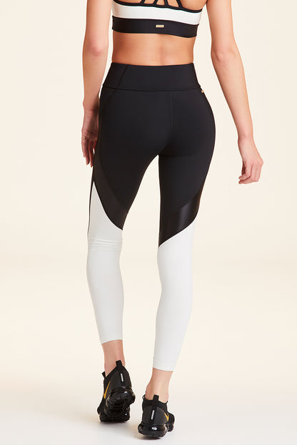 Back view of Alala Women's Luxury Athleisure black and cream color-blocked tight