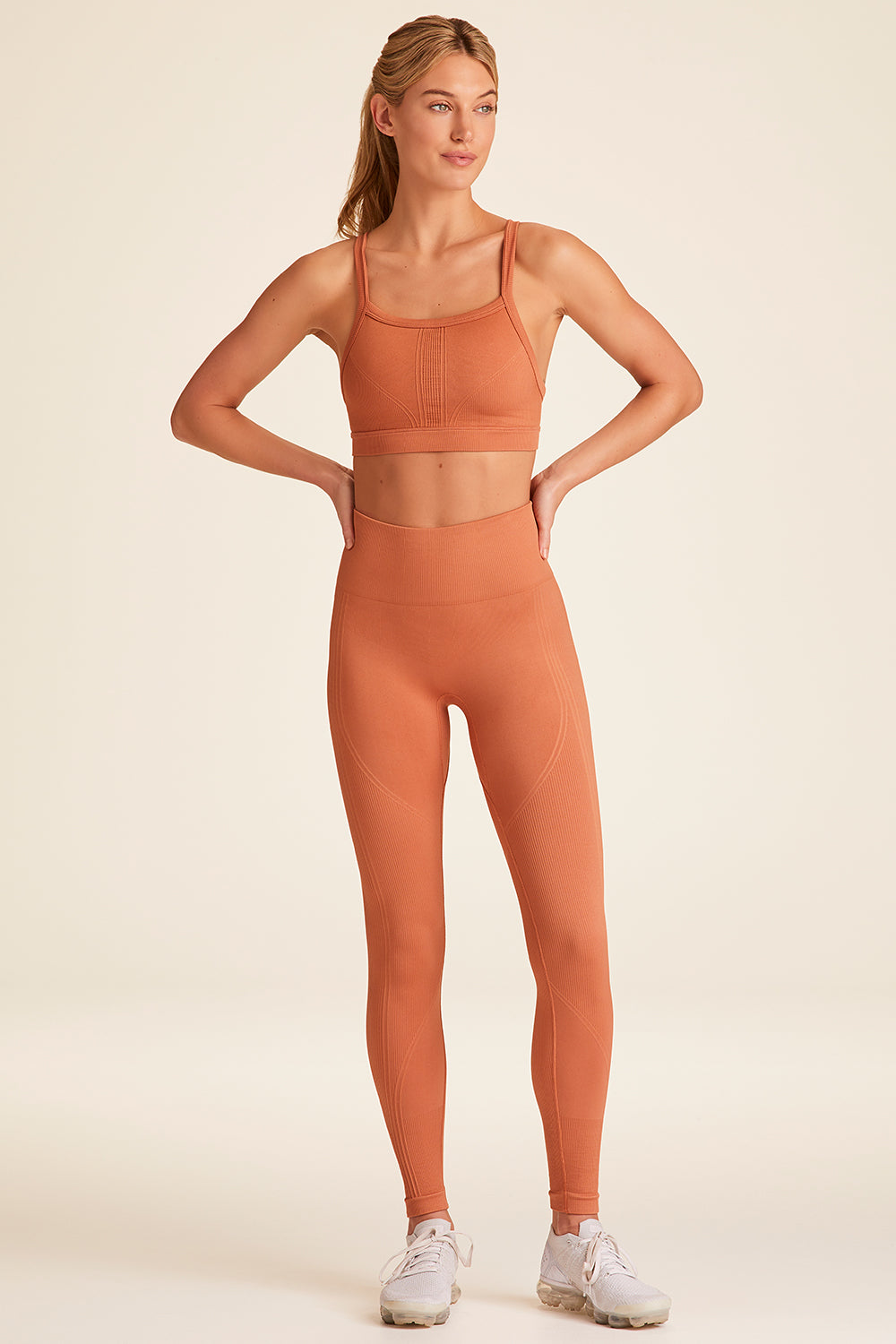 Front full body view of Alala Luxury Women's Athleisure flow seamless tight in terracotta