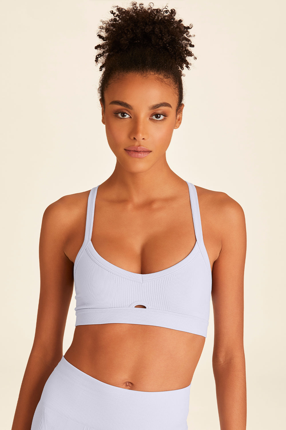 Front view of woman wearing baby blue Barre Cami Bra from Alala