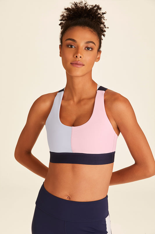 Front view of model with hands behind back wearing navy, pink, and blue Blocked Eclipse Bra
