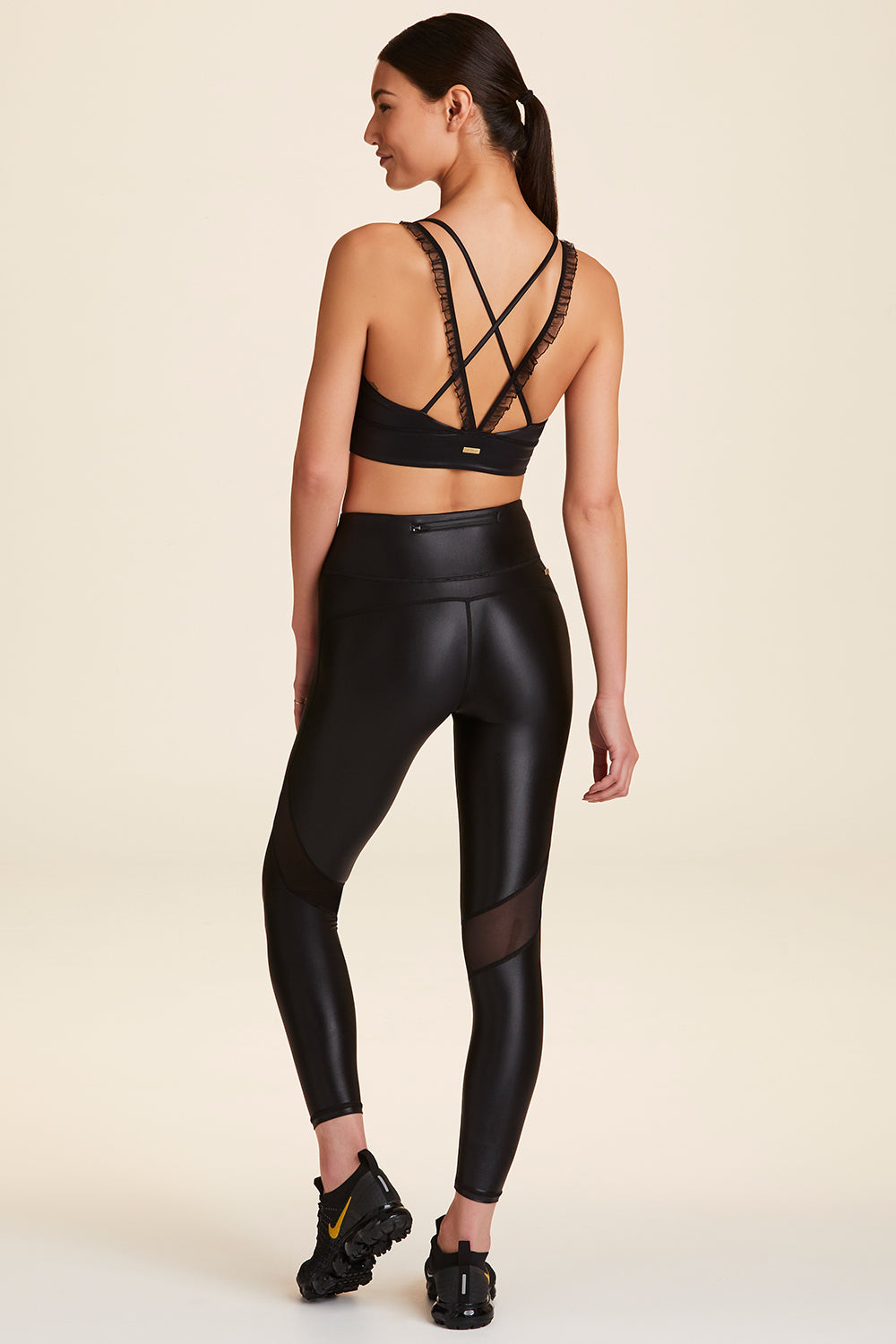 Back full body view of Alala Women's Luxury Athleisure ribbon bra in black liquid black with ribbon detailing on straps