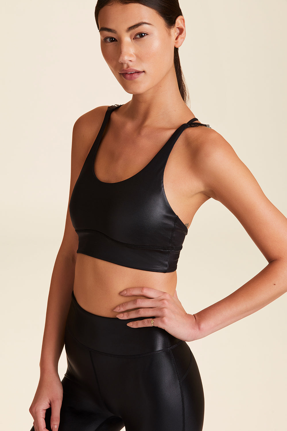 Side view of Alala Women's Luxury Athleisure ribbon bra in black liquid black with ribbon detailing on straps