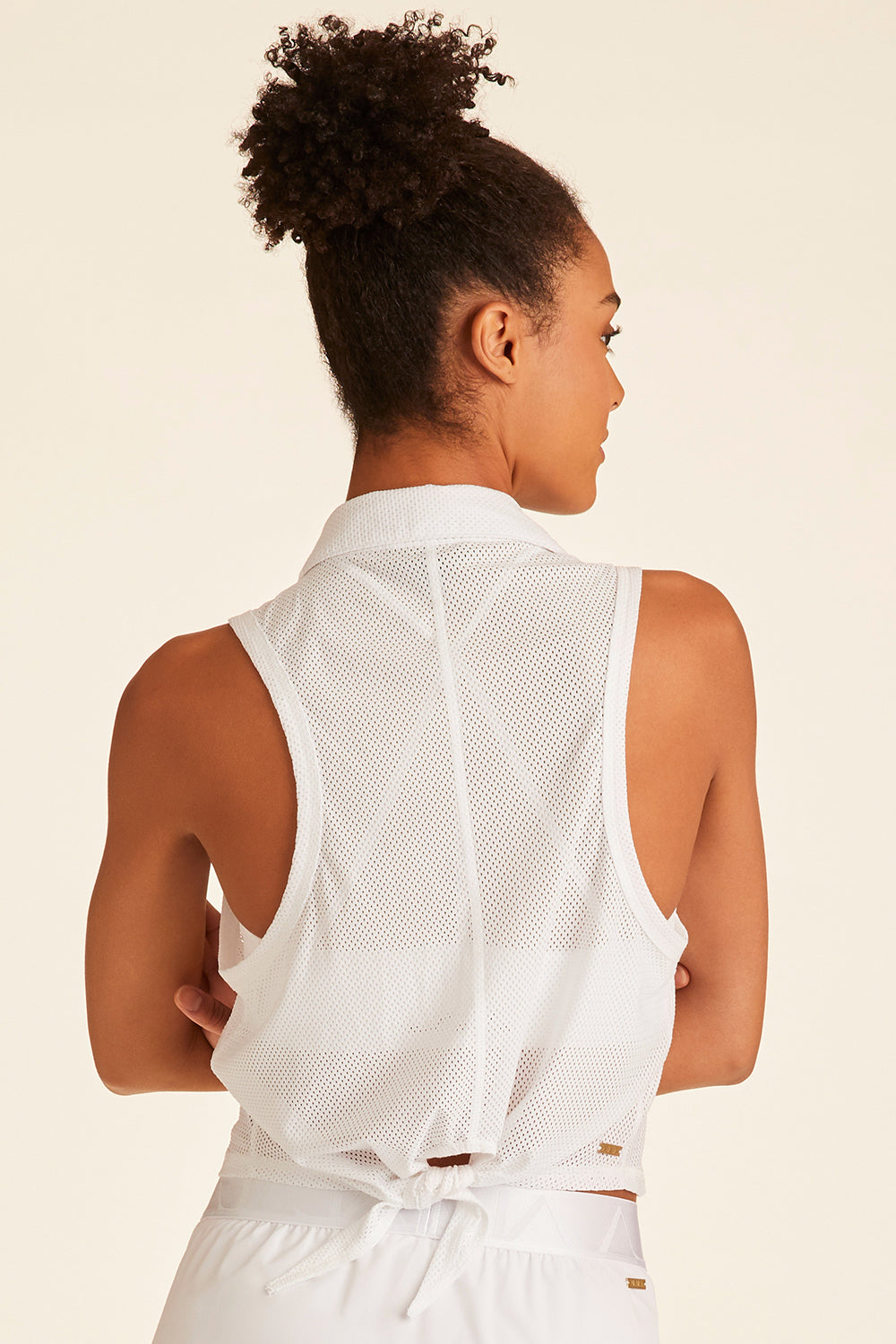 Back view of woman with arms crossed showing back tie detailing of white Tie Back Polo