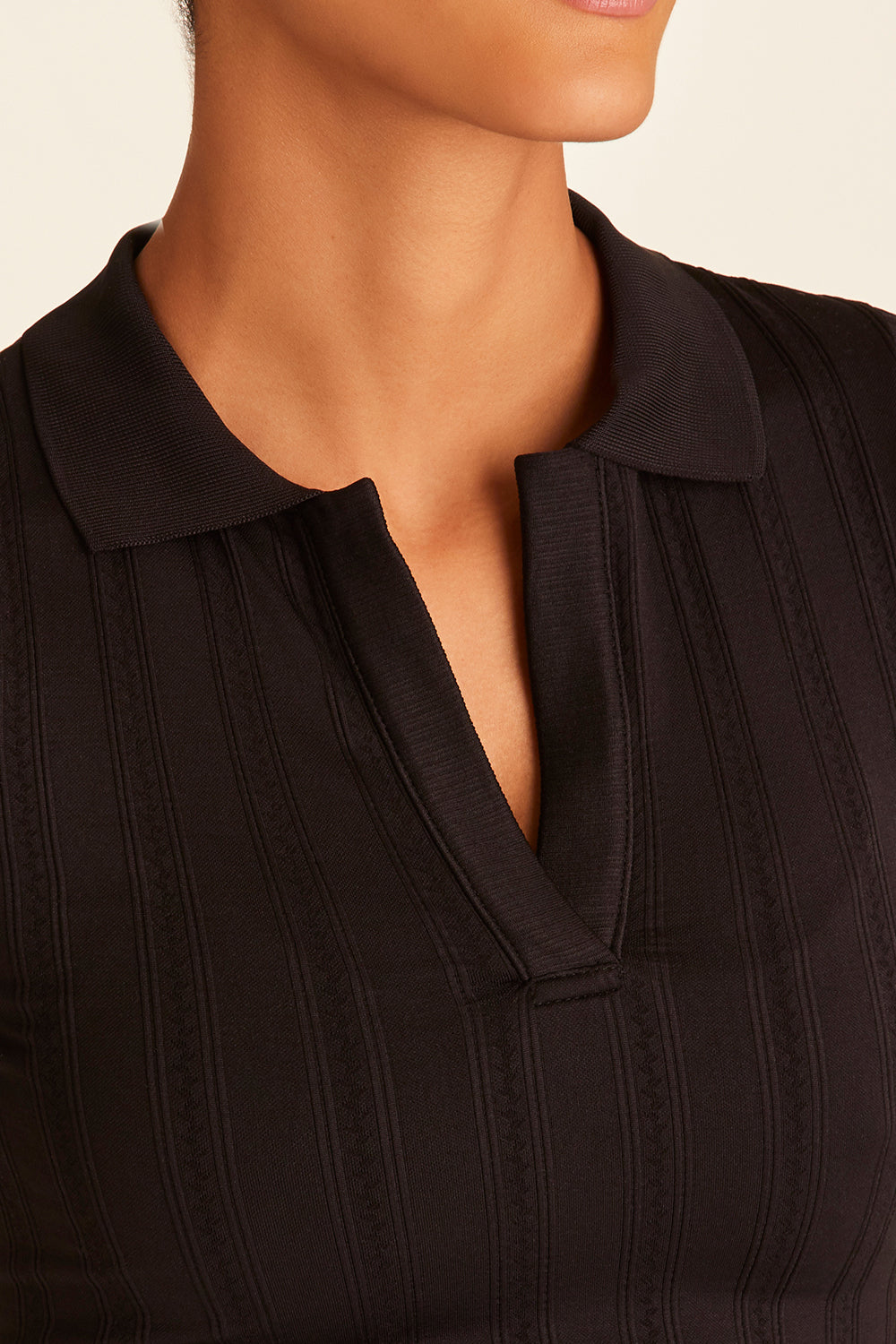 Closeup of model wearing black Seamless Polo showing collar details