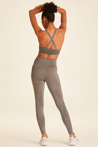 Full body back view of model with hands above head wearing grey Barre Cami Bra