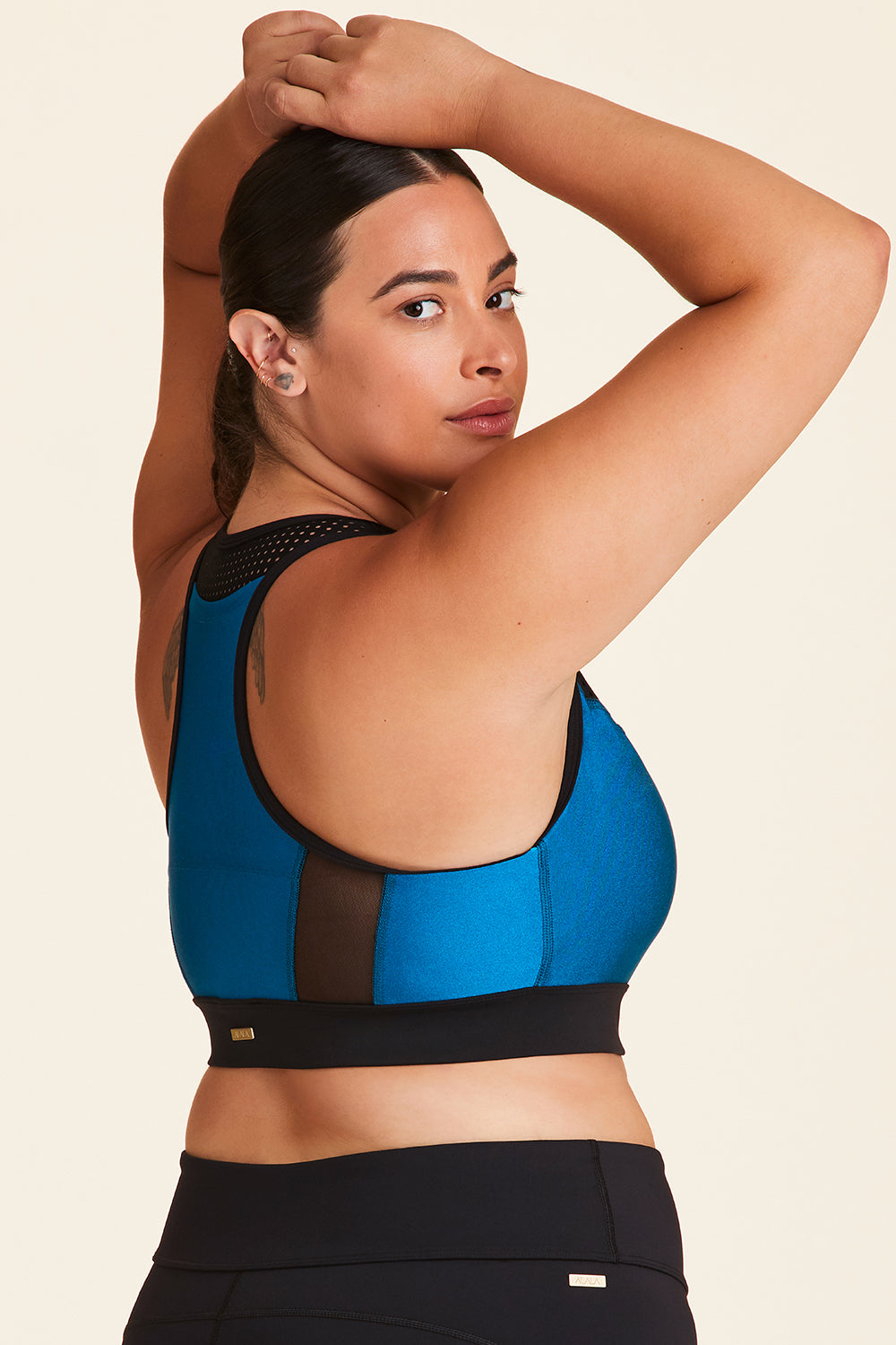 Back view of Alala Women's Luxury Athleisure black and teal sports bra with mesh detail in plus size