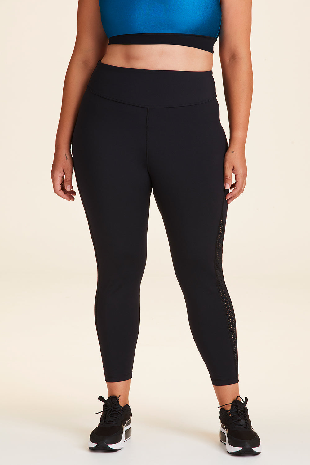 Front view of Alala Women's Luxury Athleisure black and teal 7/8 tight with minimal mesh detail in plus size