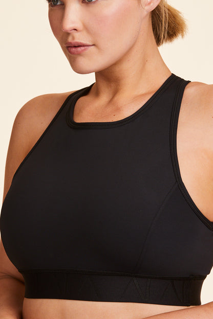 Front view of Alala Women's Luxury Athleisure black racerback bra in plus size