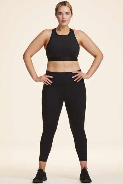 Front view of Alala Women's Luxury Athleisure black tight with minimal mesh detail in plus size