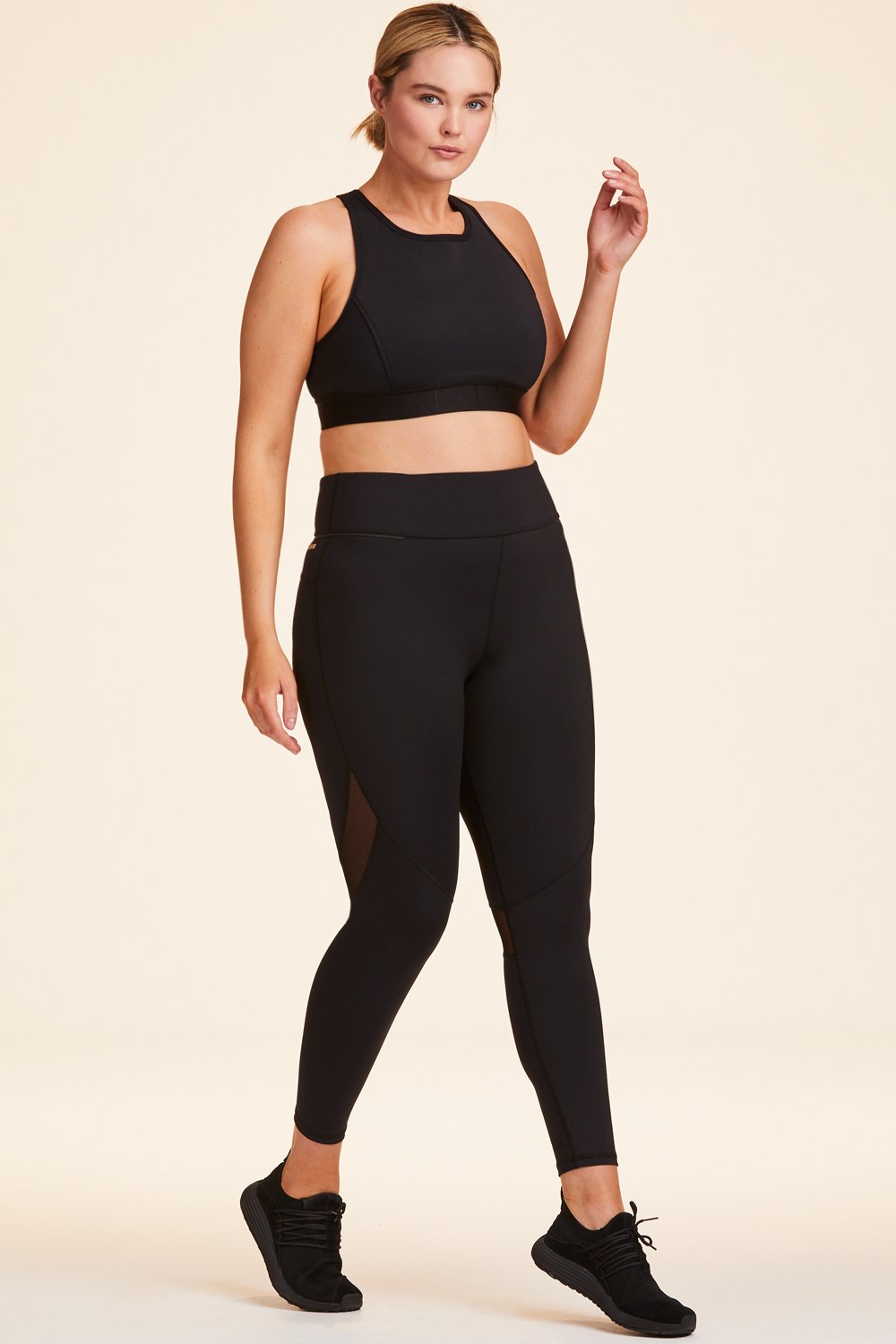 3/4 view of Alala Women's Luxury Athleisure black tight with mesh paneling on back of knees