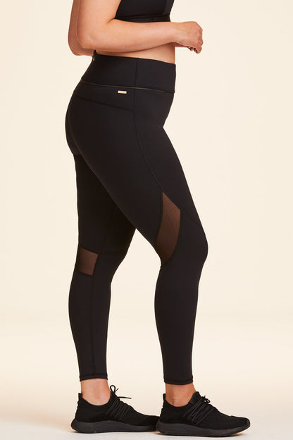 Side view of Alala Women's Luxury Athleisure black tight with mesh paneling on back of knees