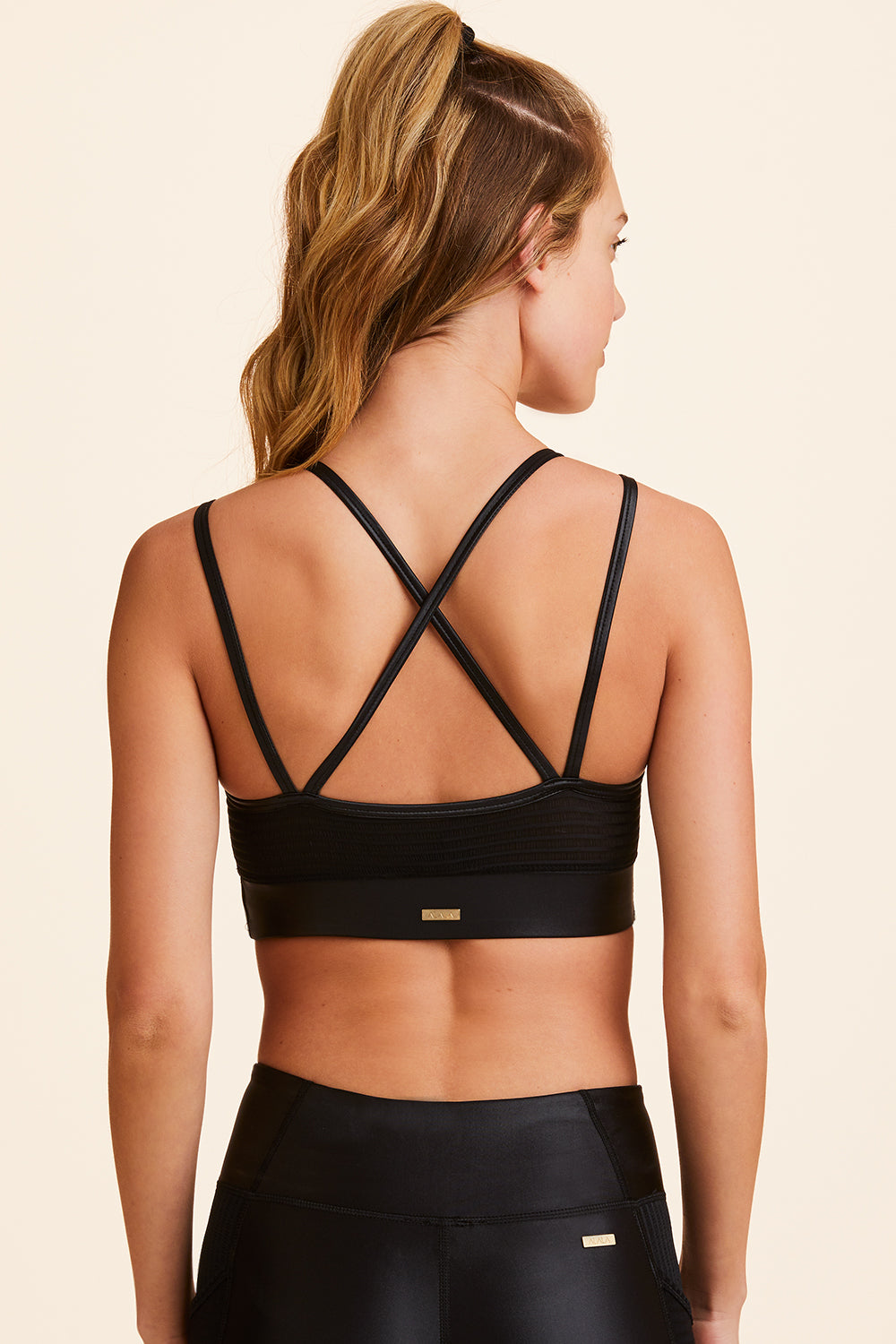 Back view of Alala Women's Luxury Athleisure black sports bra with double straps
