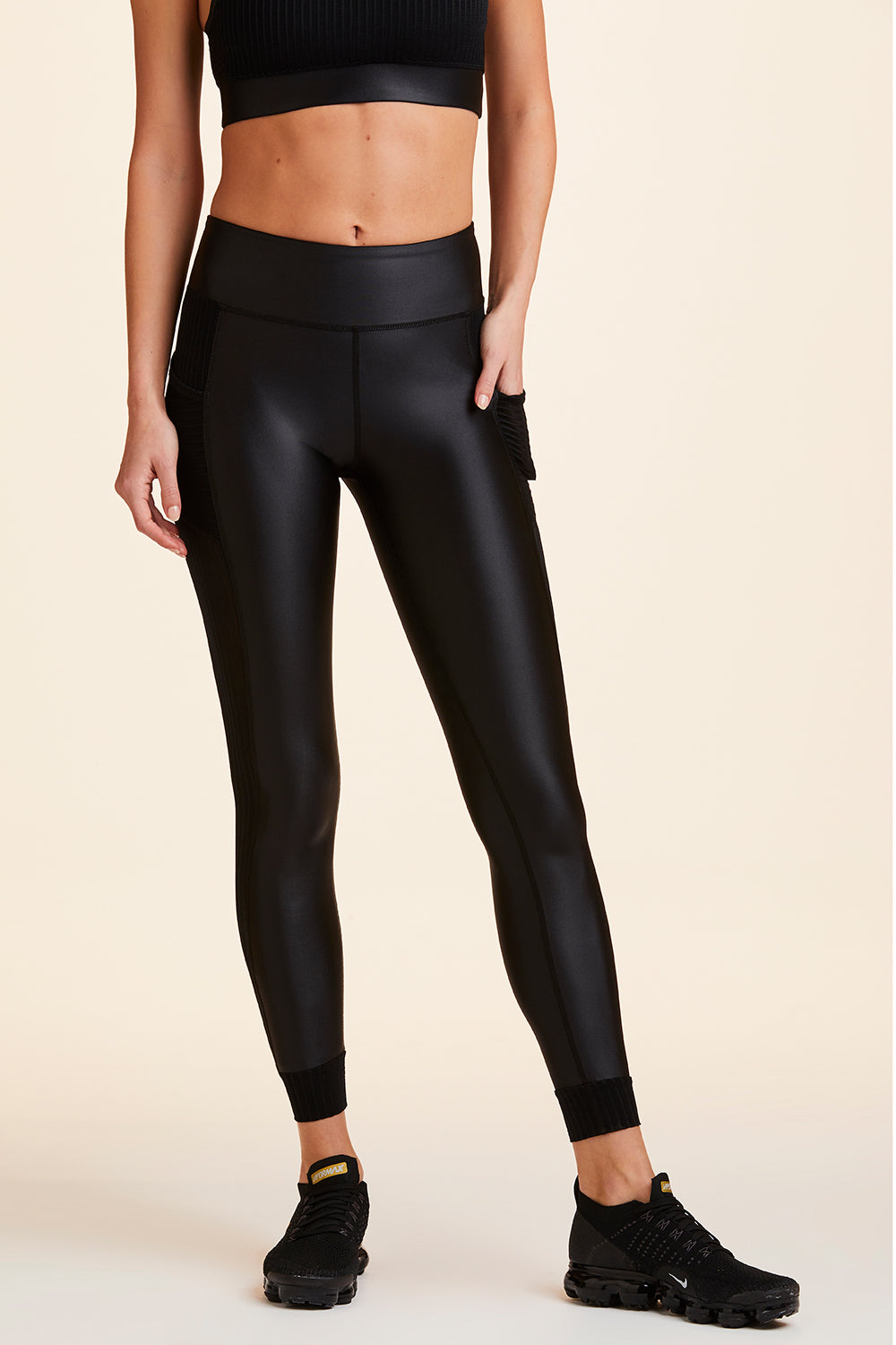 Front view of Alala Women's Luxury Athleisure shiny black tight with sheer ribbed detail