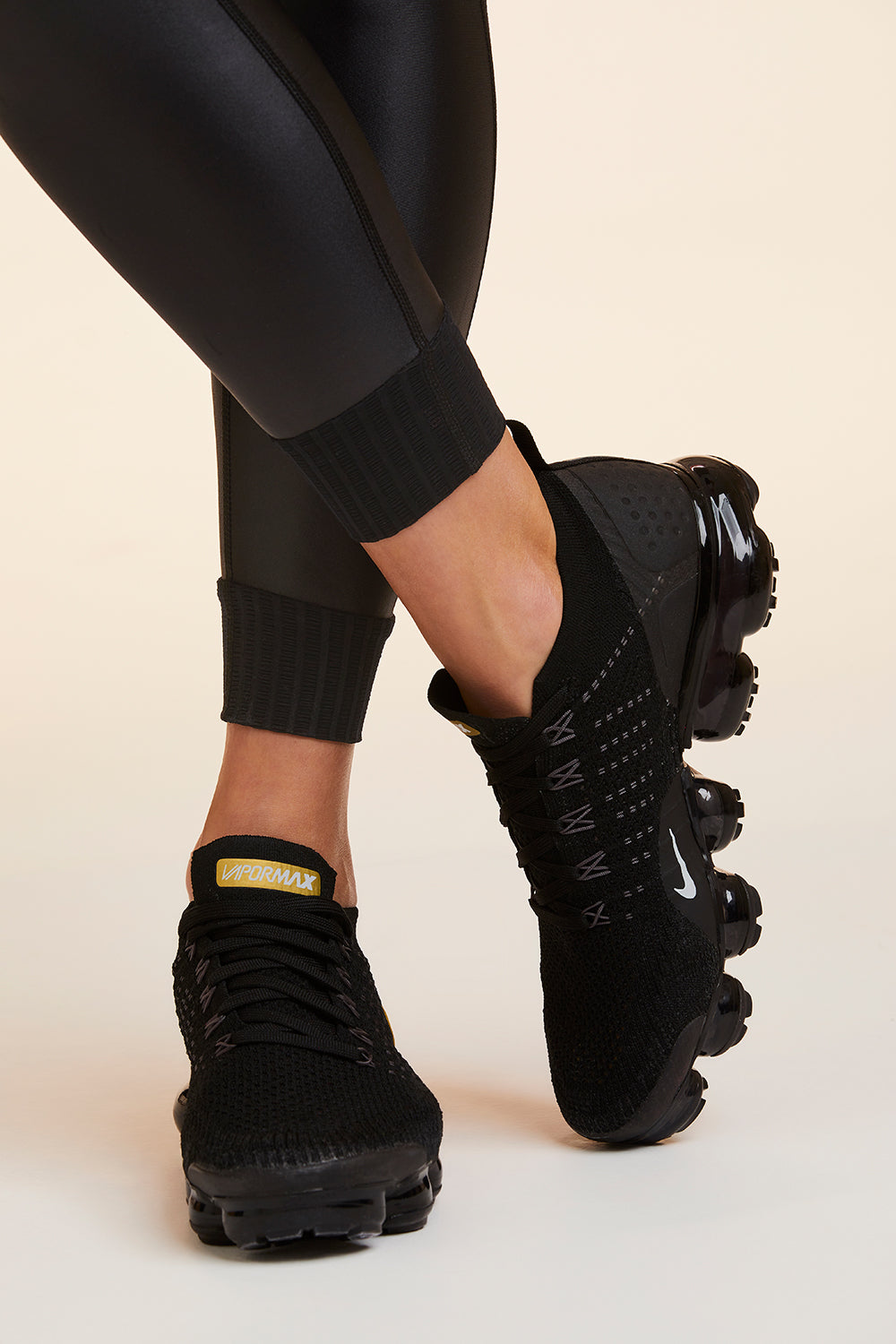 Close-up view of Alala Women's Luxury Athleisure shiny black tight with sheer ribbed detail