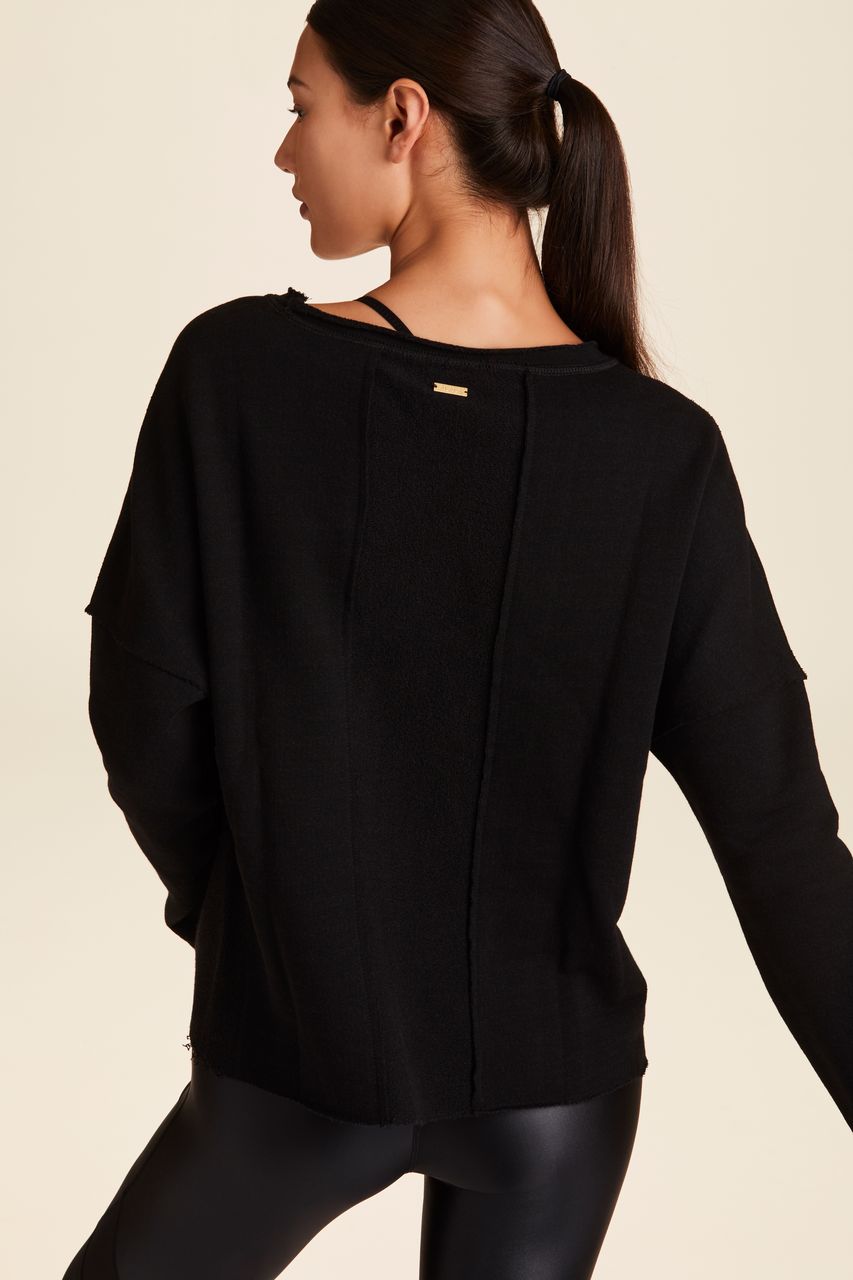 Back view of Alala Women's Luxury Athleisure black sweatshirt with distressed details on seams